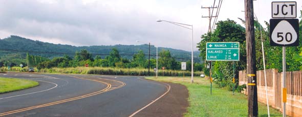 East end of state route 540 at junction with state route 50, with sign indicating in both miles and kilometers distances to Waimea to the left, and Kalaheo and Lihue to the right