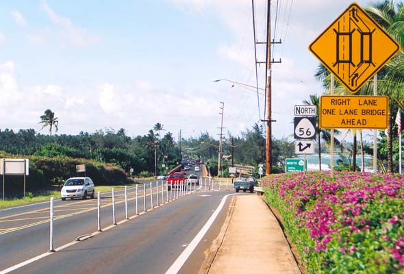 Signs indicating split of two northbound lanes on route 56 at the Wailua River crossing, one lane on the two-lane main bridge, and the other on a separate one-lane bridge