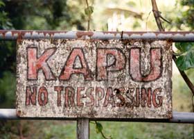 Rusted gate sign: 'Kapu | No Trespassing'
