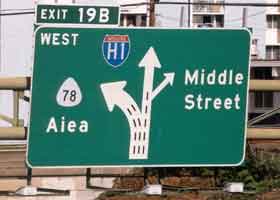 Overhead sign, showing westbound traffic pattern at exit 19B -- three lanes split to left from H-1, two lanes continue as H-1, right exit for Middle Street
