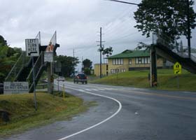 Turnoff to left from southbound Hawaii Belt Road (state route 19) to Onomea Bay scenic drive, in front of dismantled old pedestrian overpass