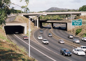 Two eastbound lanes of H-1 emerge from Middle Street Tunnel, merge with three eastbound lanes of Moanalua Freeway