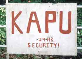 White gate sign: 'Kapu | 24 hr security'