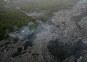 Overhead view from northwest of lava flowing over pavement at west end of access road
