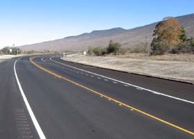 More smooth pavement at the west end of the new alignment, with right turn lane to the turnoff for Mauna Kea State Park