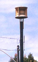 Civil defense siren, one yellow enclosure directing sound in all directions