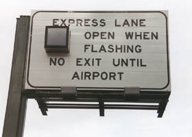 Overhead:  "Express Lane Open When Flashing, No Exit Until Airport"