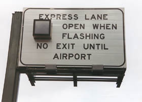 Overhead: "Express Lane Open When Flashing, No Exit Until Airport"